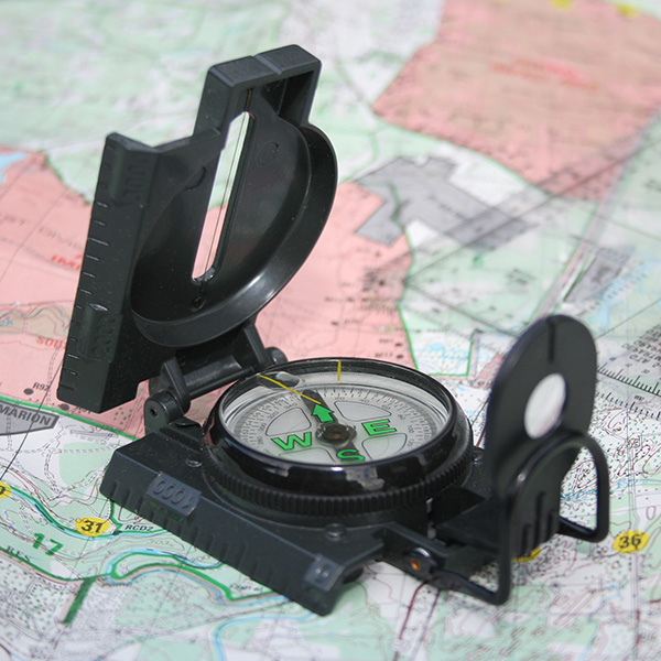 A compass sitting on top of a paper map